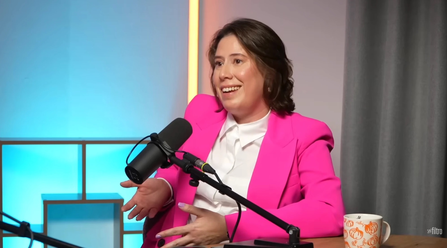 Cristina Peñaloza speaking into a microphone during a podcast interview